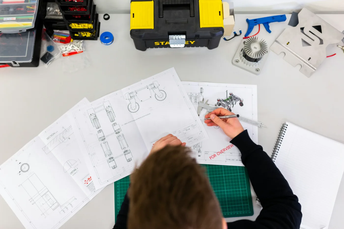 Precision tools and technical drawings on a workbench